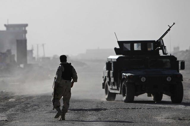 A member of the Afghan security forces walks towards the site of the attack in Kabul