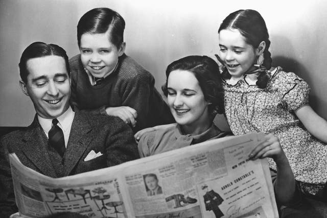 An American family reading a newspaper circa 1950