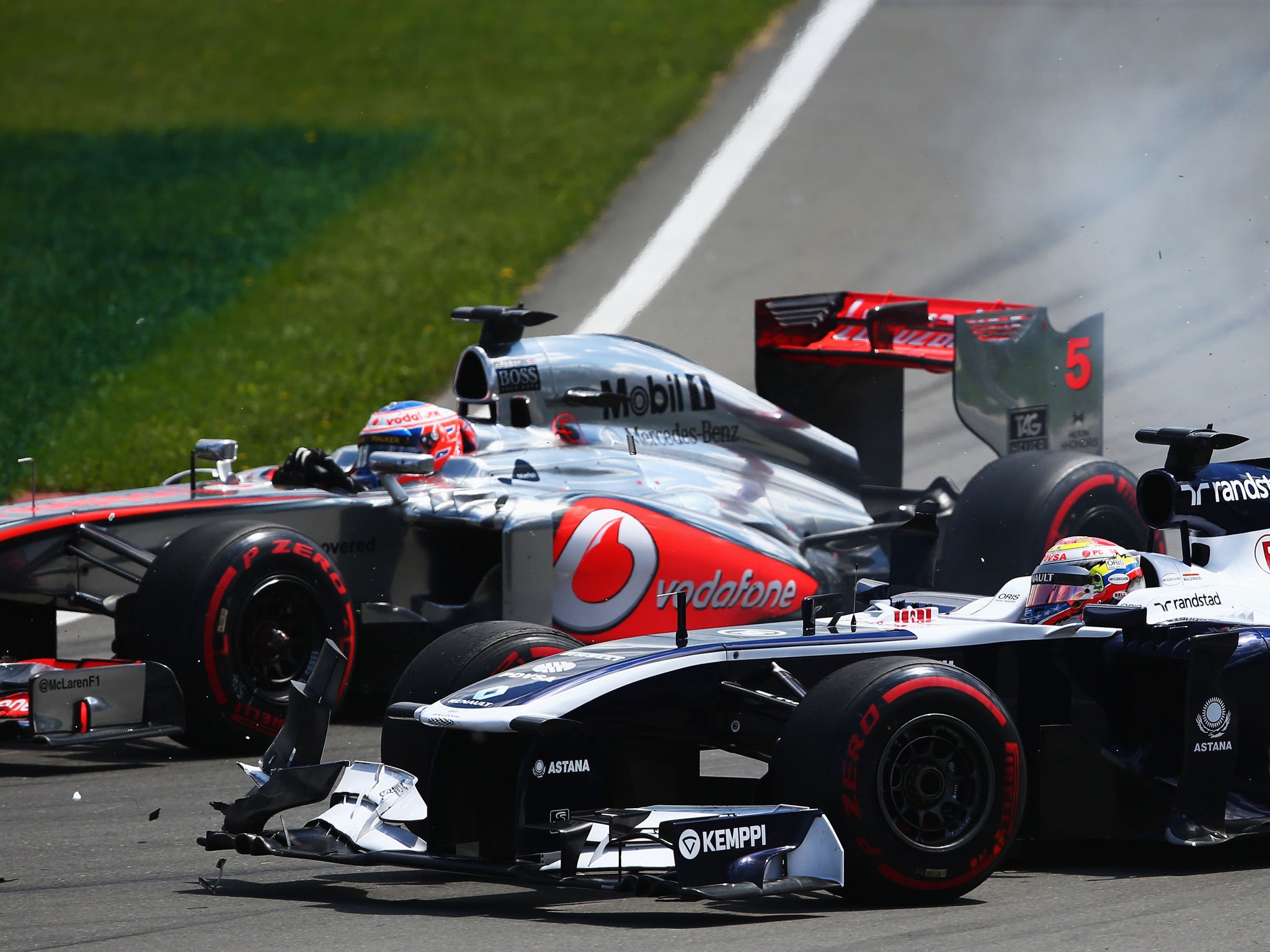 Jenson Button of Great Britain and McLaren and Pastor Maldonado of Venezuela and Williams drive side by side into the hairpin during the Canadian Formula One Grand Prix