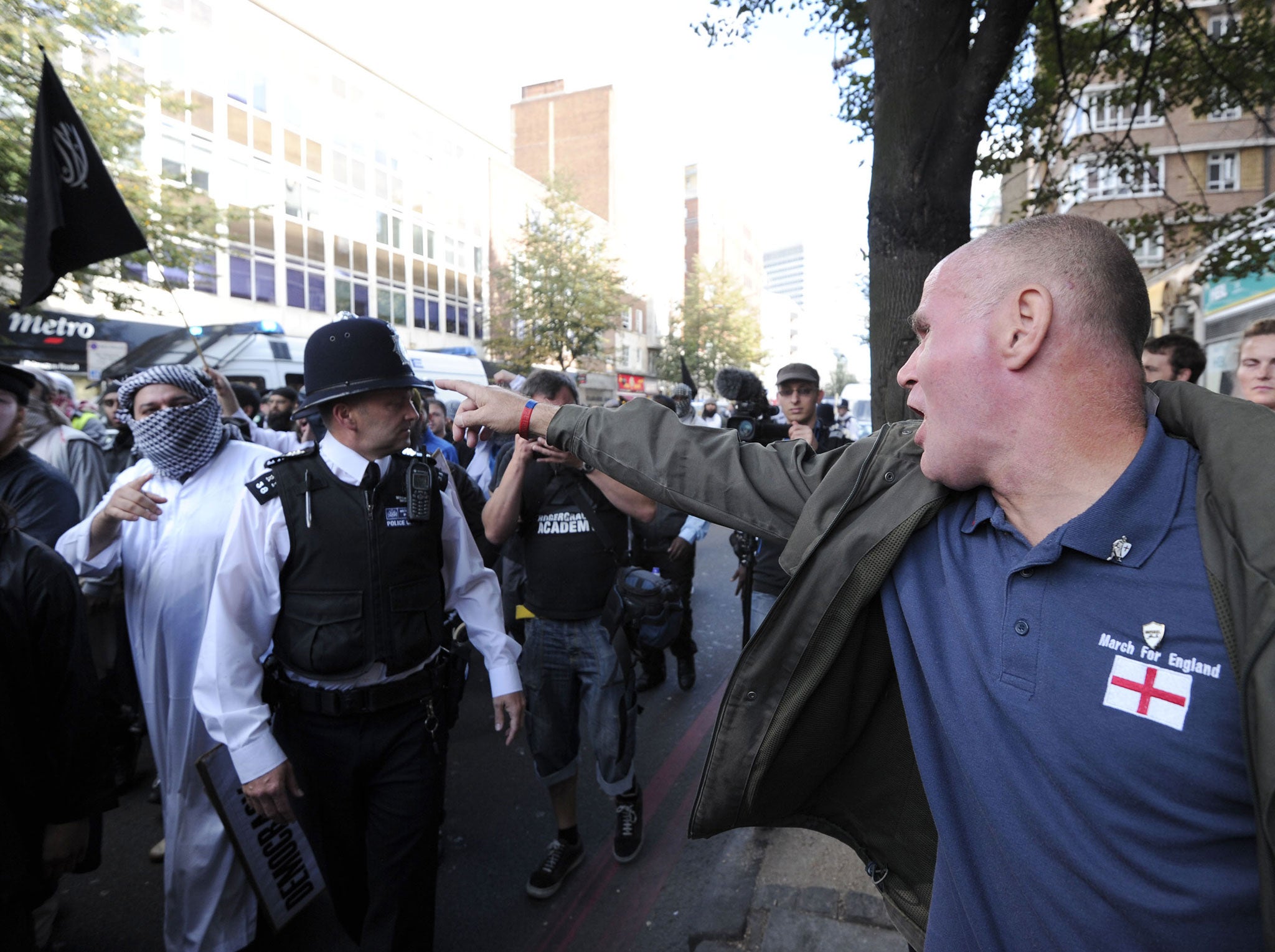 A member of the right-wing English Defence League (EDL) shouts at police escorting Islamist demonstrators after their protest outside the US embassy in London on September 11, 2011 during a ceremony to mark the 10th anniversary of the 9/11 attacks on the United States.