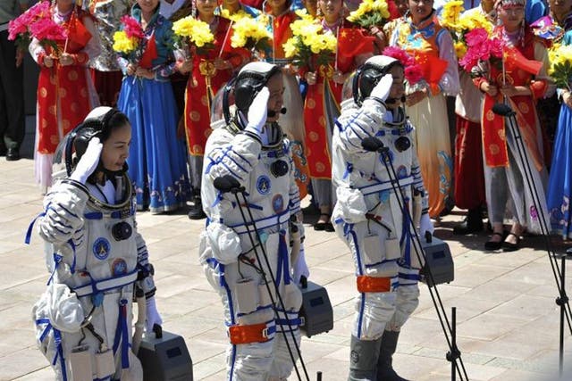 Chinese astronauts (front L-R) Wang Yaping, mission commander Nie Haisheng and Zhang Xiaoguang prepare to board the Shenzhou-10 spacecraft
