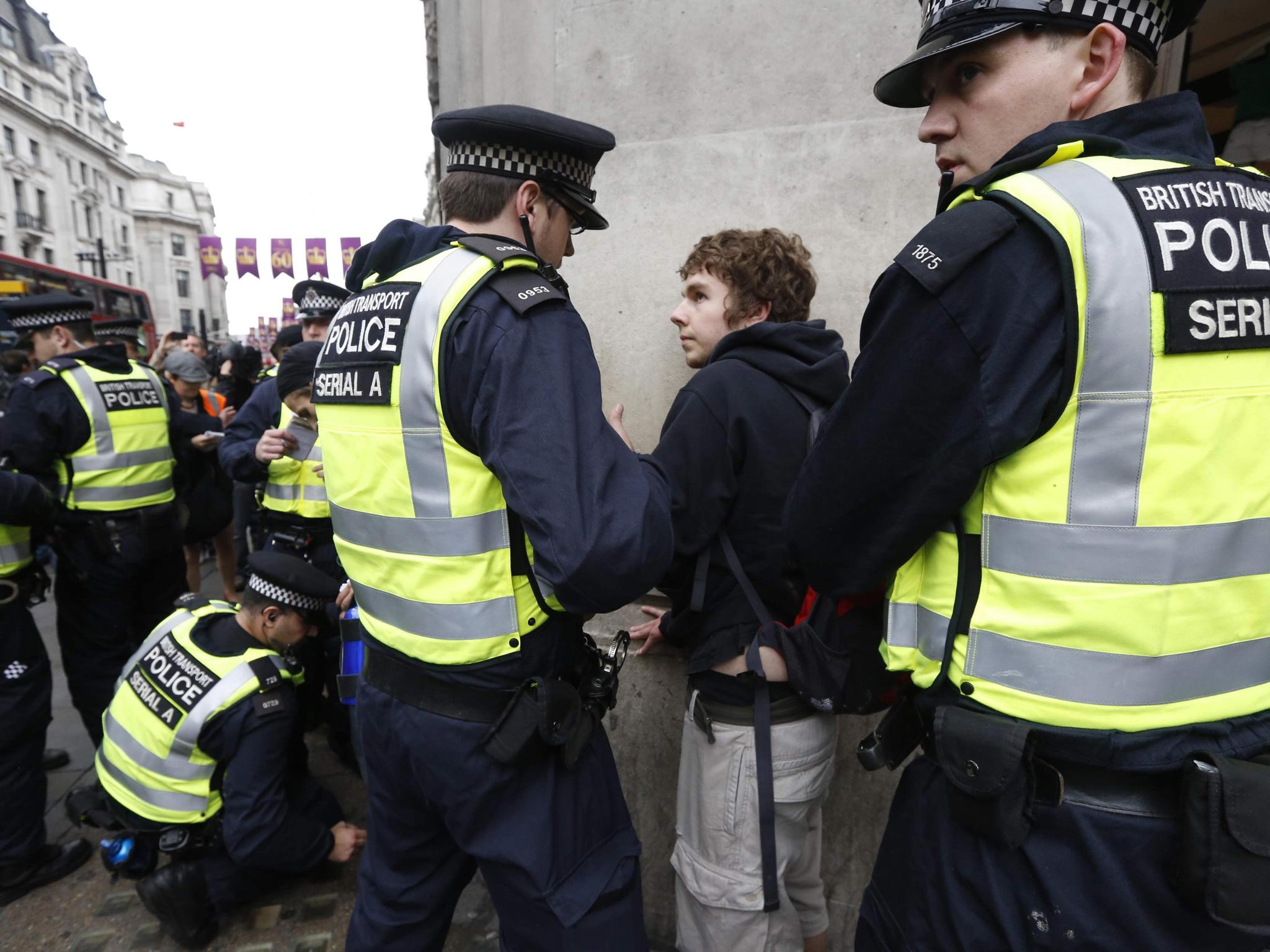 Police officers detain a protester demonstrating against the upcoming G8 summit in central London