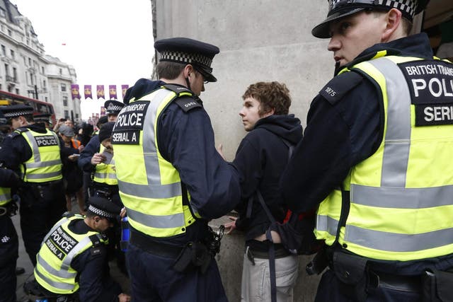 Police officers detain a protester demonstrating against the upcoming G8 summit in central London