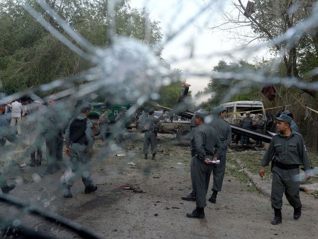 Afghan policemen around the wreckage of a vehicle which was used in the suicide attack near Kabul's top court