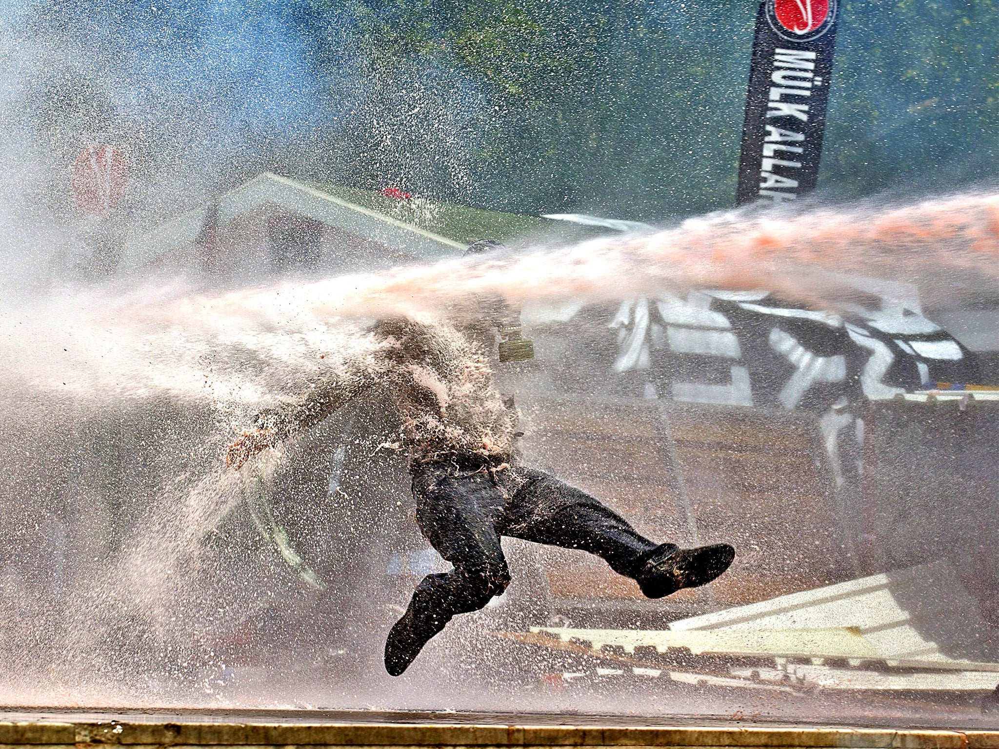A protestor is hit by water sprayed from a water cannon during clashes in Taksim Square