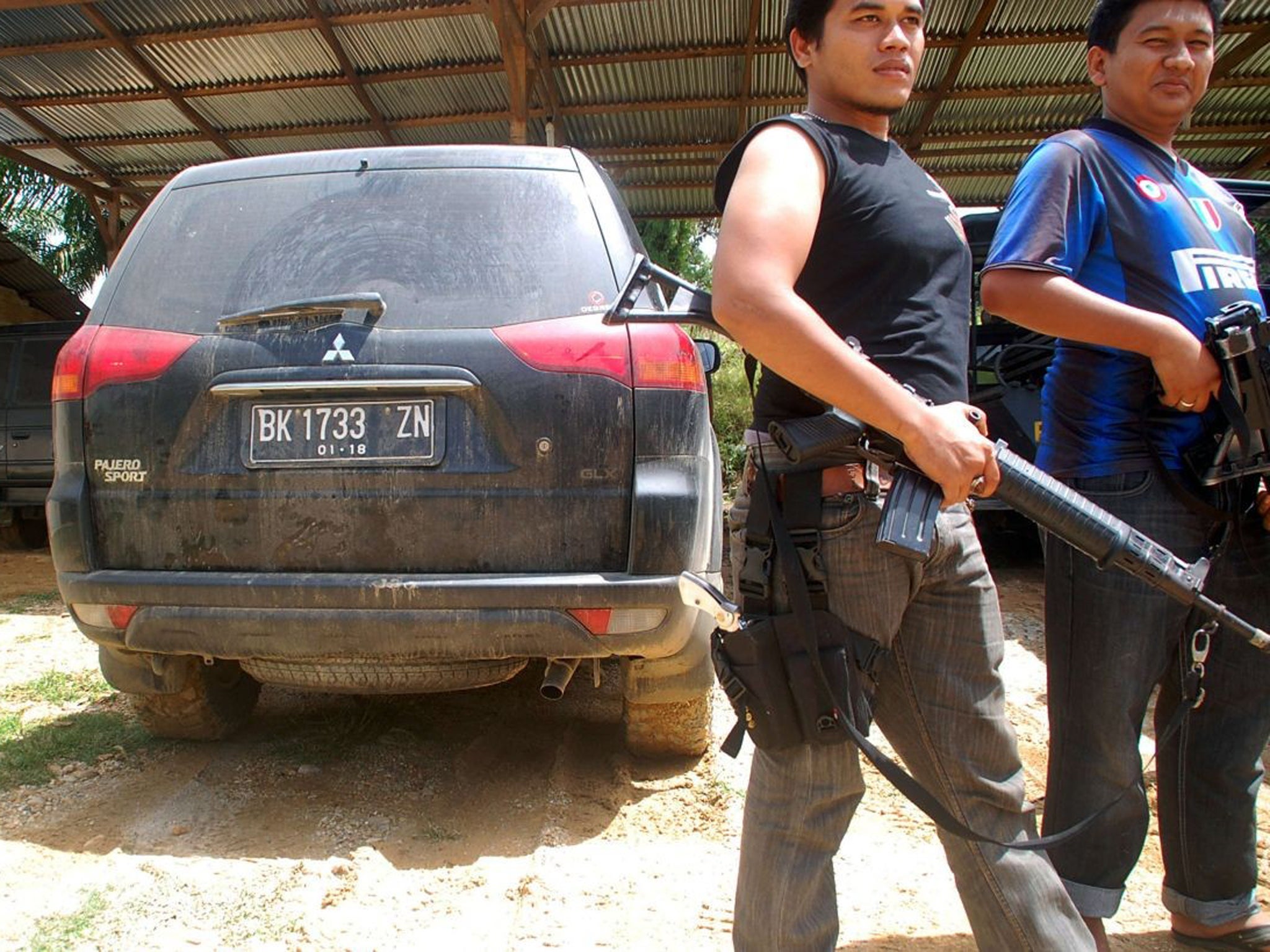 Indonesian policemen stand guard next to a car reportedly used by a British man kidnapped in East Aceh