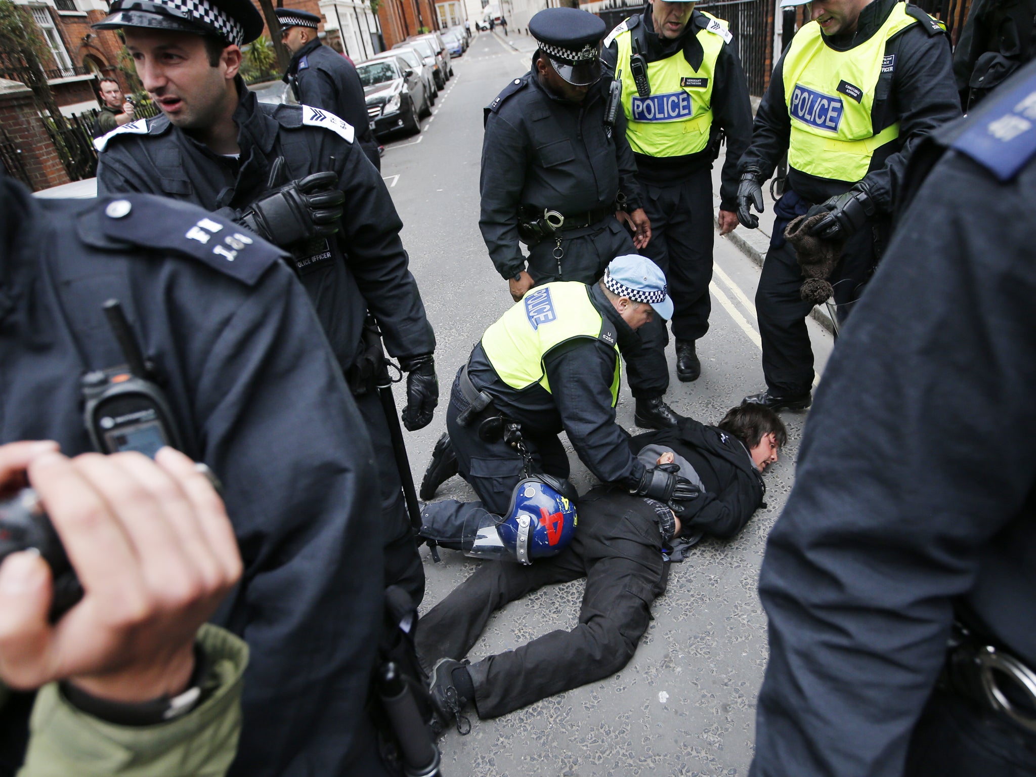 Police detain an anti-capitalist protester in London on 11 June 2013