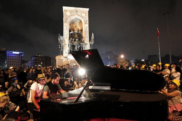 German pianist Klavier Kunst (L) performs with an unidentified activist at Taksim Square in Istanbul, Turkey