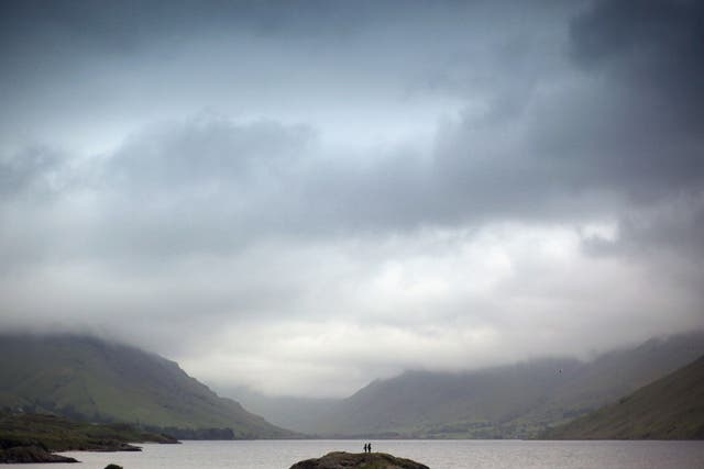Children paddle against the backdrop of Wastwater in the Lake District