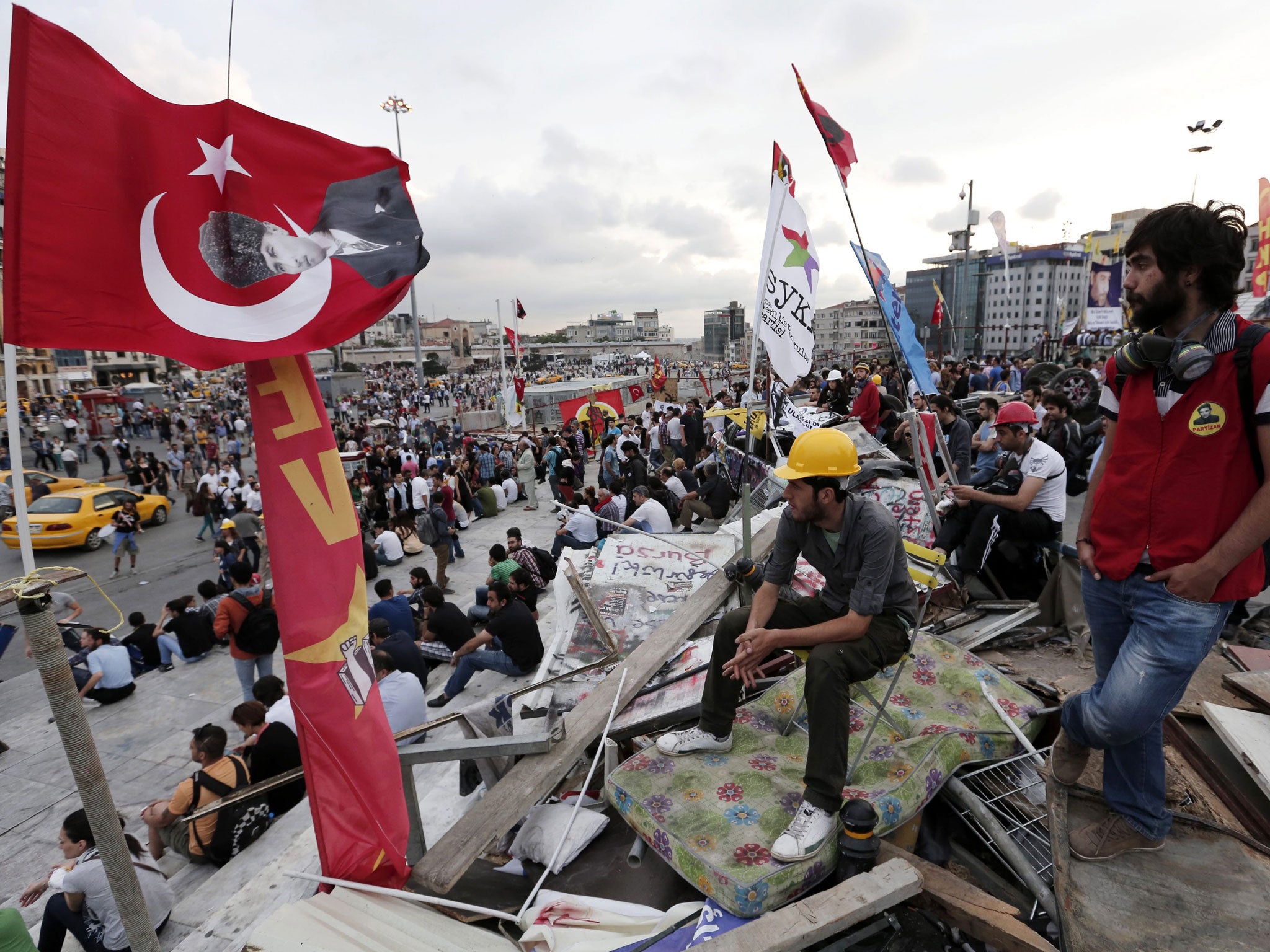 Anti-goverment protesters unfurl the Turkish national flag in Taksim
