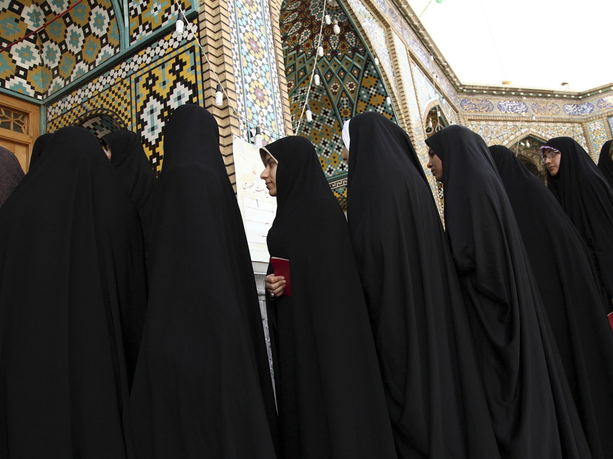 Women stand in line to vote during the Iranian presidential election at a mosque in Qom, Iran