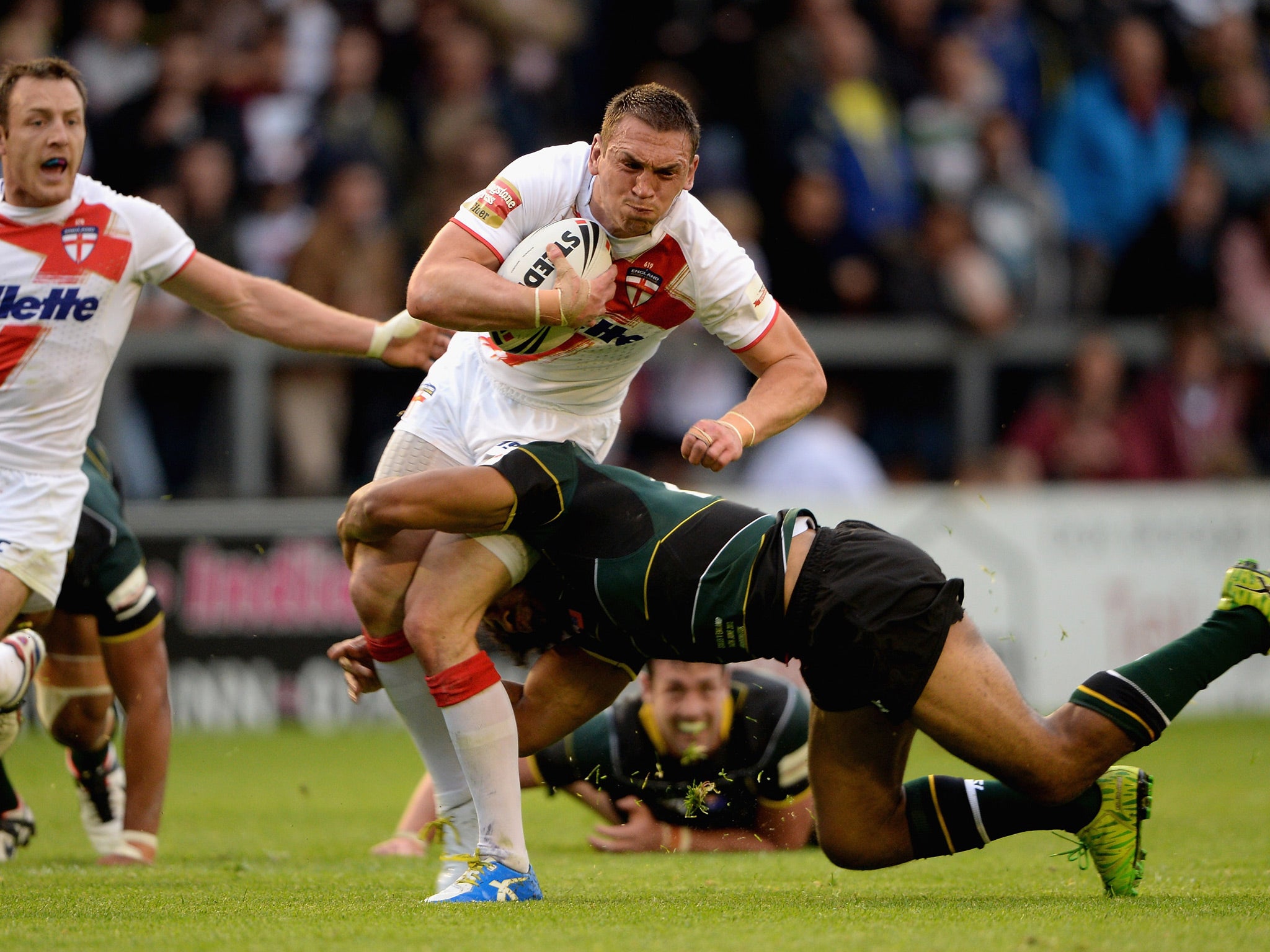 England captain Kevin Sinfield attempts to break the tackle of Sia Soliola