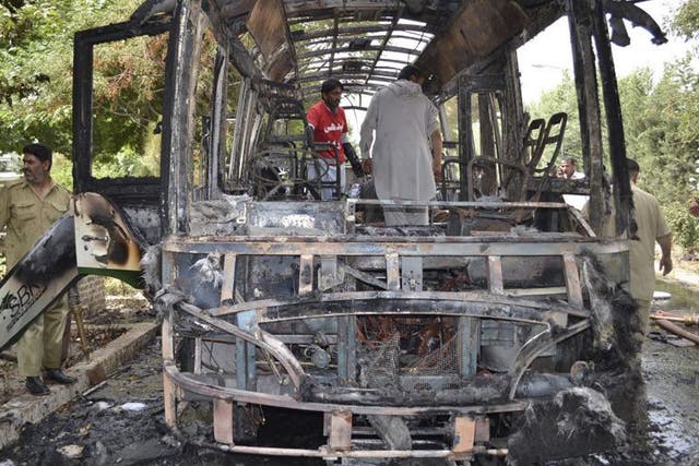 Pakistani volunteers comb the remains of the bus following the bombing