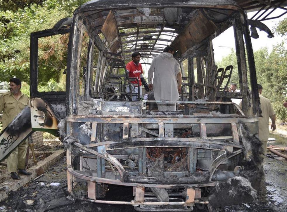 Pakistani volunteers comb the remains of the bus following the bombing