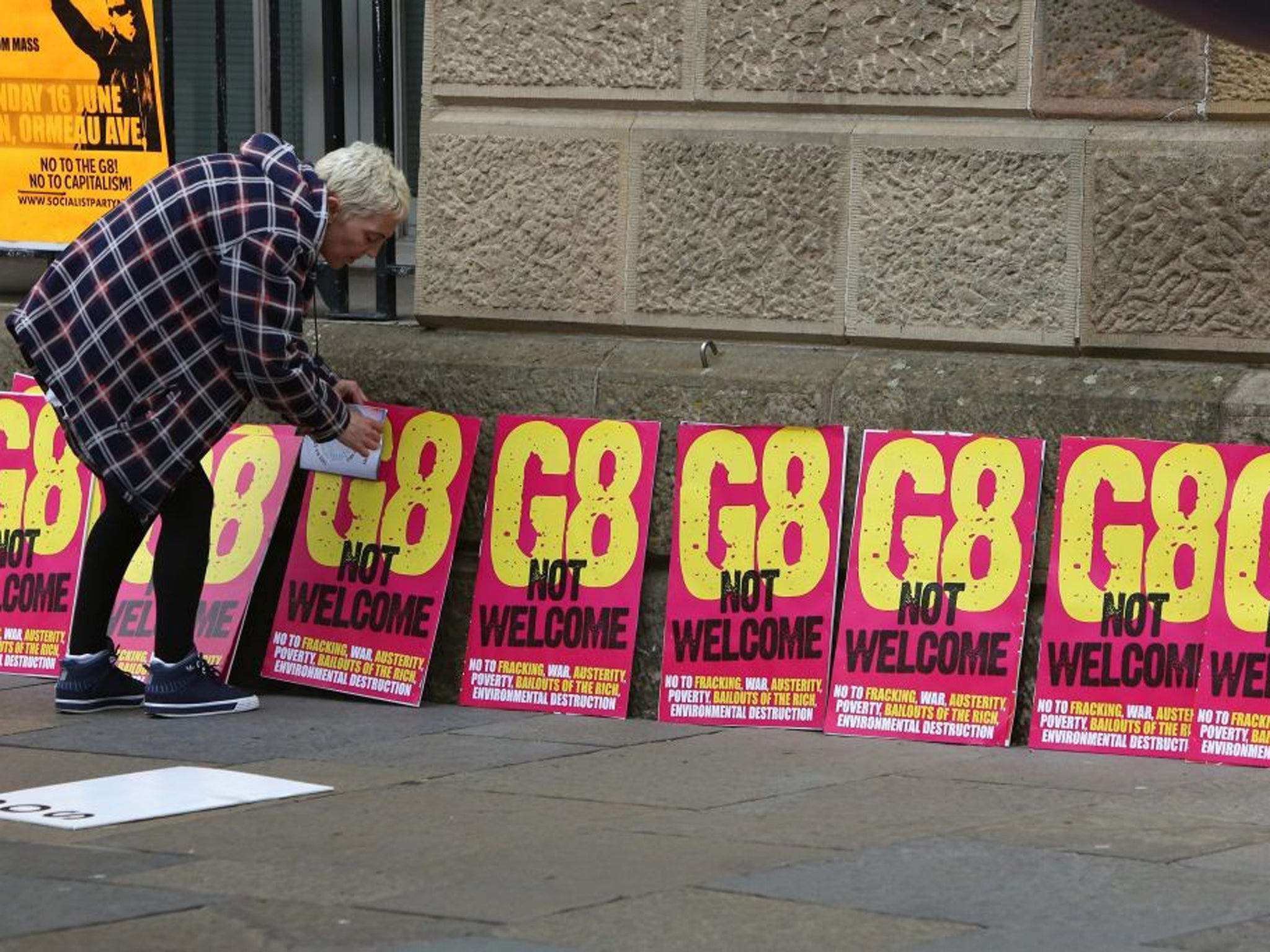15 June 2013: A protester lays out placards as around 2,000 people marched through Belfast, Northern Ireland, ahead of the G8 summit in County Fermanagh which begins on Monday