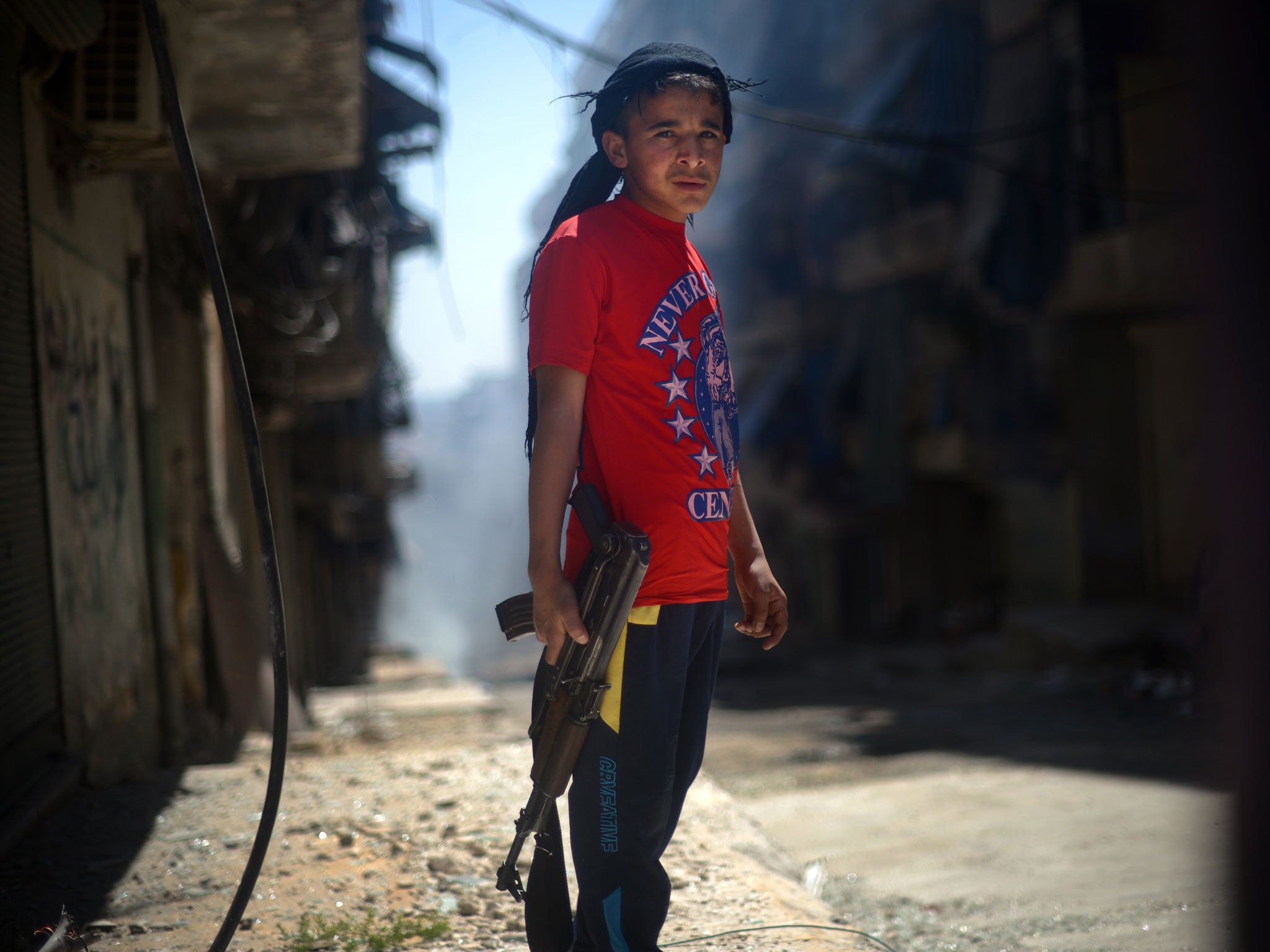 Street fighter: A youth with an AK-47 in the Kurdish district of Aleppo
