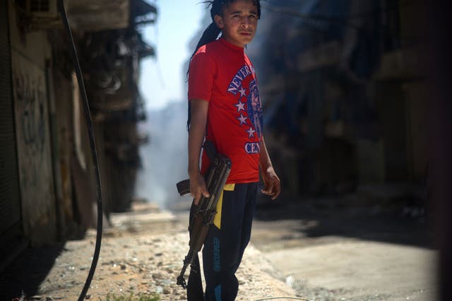 Street fighter: A youth with an AK-47 in the Kurdish district of Aleppo
