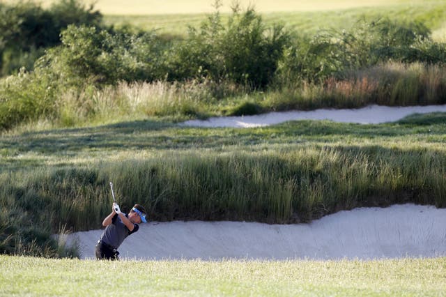 Pretty lethal: Ian Poulter attempts to blast out of a sand trap on the 16th hole as he completed his second round
