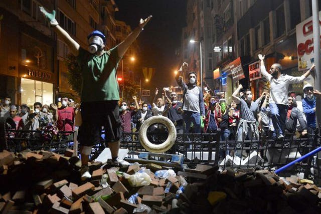 Protesters shouting anti-government slogans from a barricade during clashes with police in Istanbul