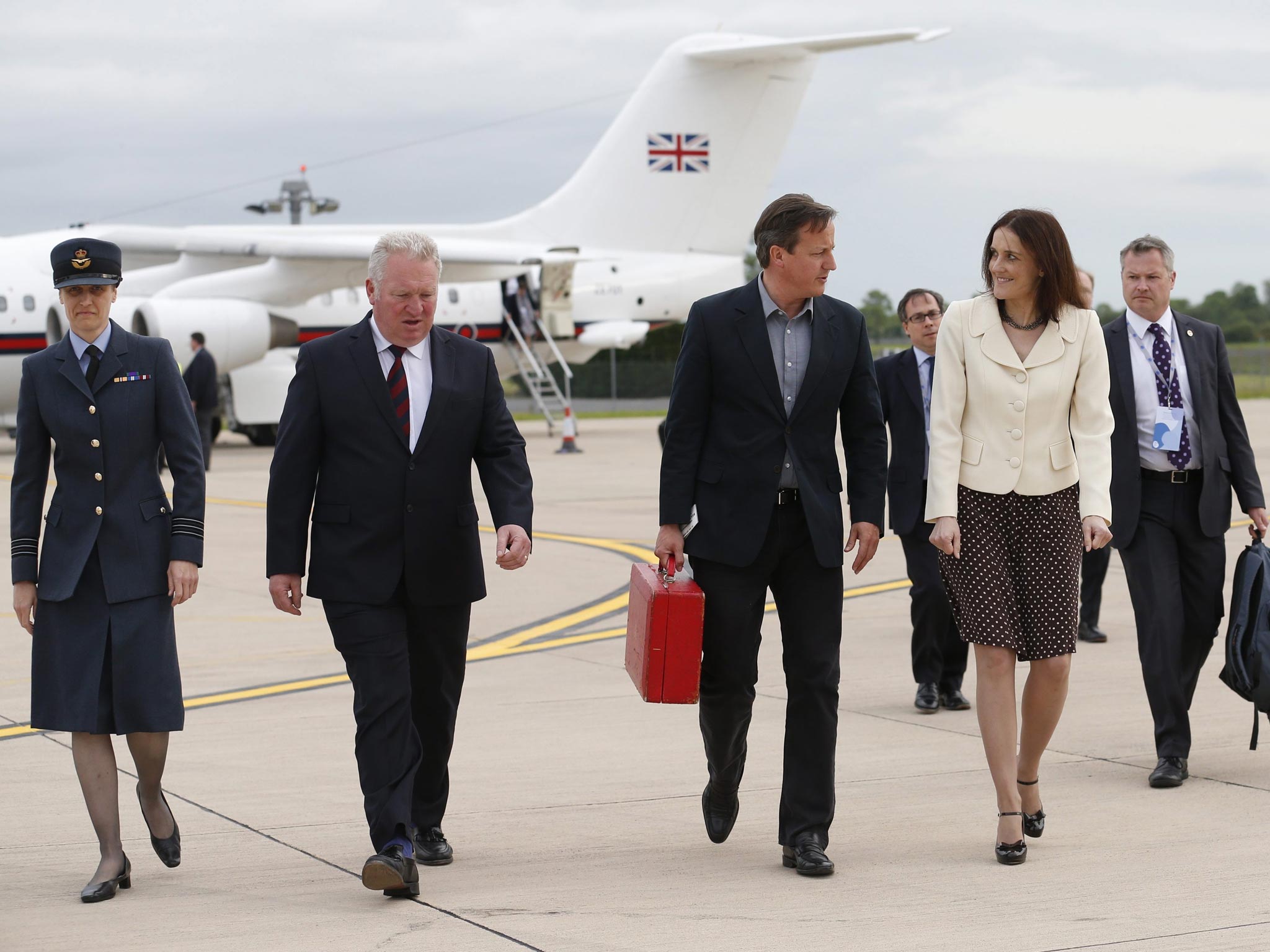 Britain's Prime Minister David Cameron walks with Northern Ireland Secretary Theresa Villiers (second right) and Wing Commander Faye Wiseman (left) after arriving in Belfast, Northern Ireland
