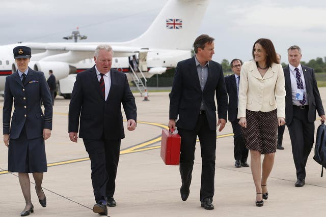 Britain's Prime Minister David Cameron walks with Northern Ireland Secretary Theresa Villiers (second right) and Wing Commander Faye Wiseman (left) after arriving in Belfast, Northern Ireland