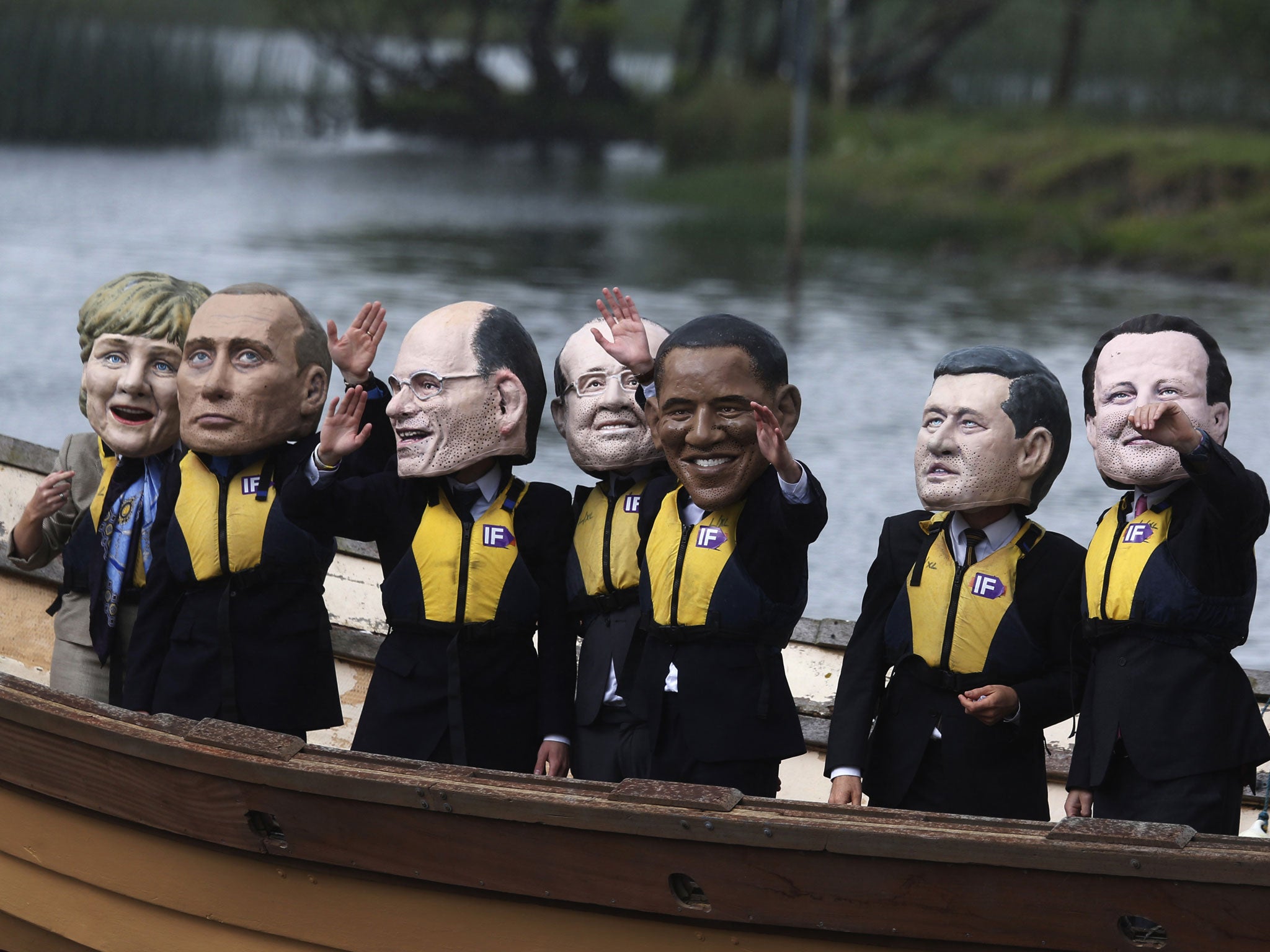 Anti-hunger activists wear giant head masks depicting the G8 leaders