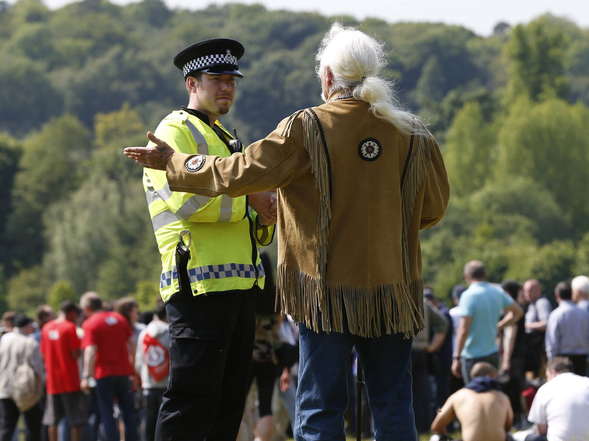 A policeman and a protester outside Bilderberg venue
