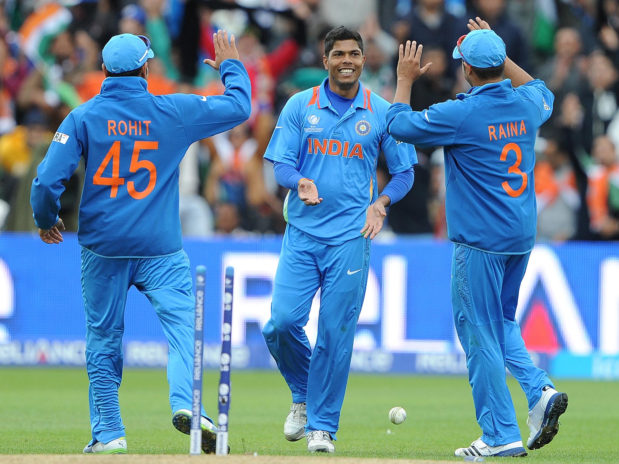 India's Suresh India's Umesh Yadav (C) celebrates with India's Suresh Raina (R) and India's Rohit Sharma after running out Pakistan's Mohammad Irfan during the 2013 ICC Champions
