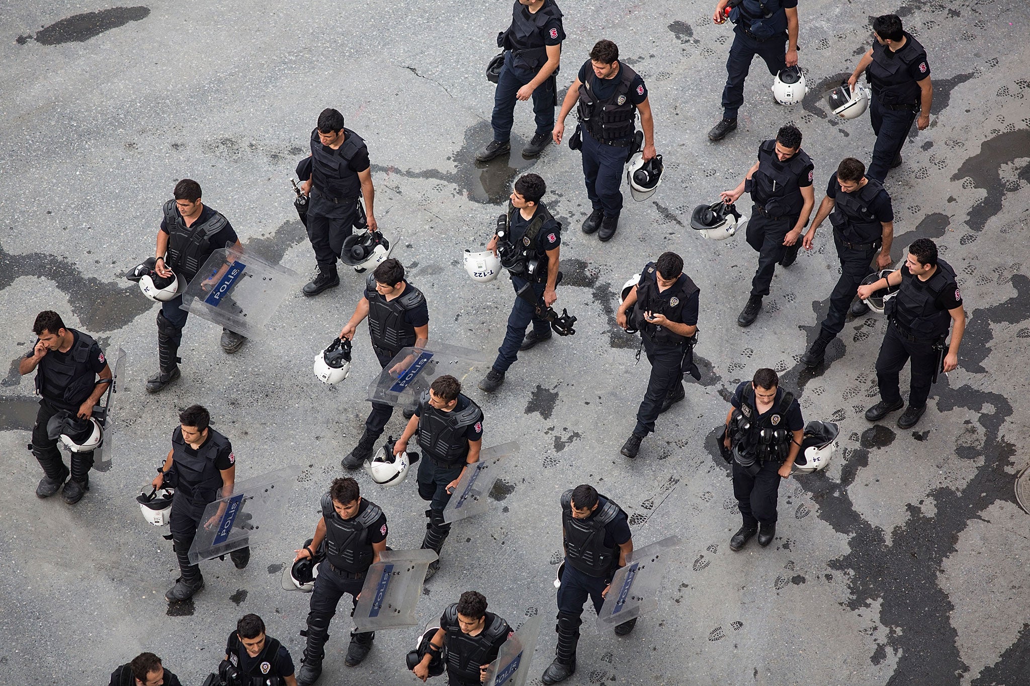 Riot police walk past Taksim Square after the crackdown action on June 16