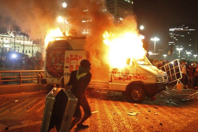 Demonstrators set fire to a car in Sao Paulo