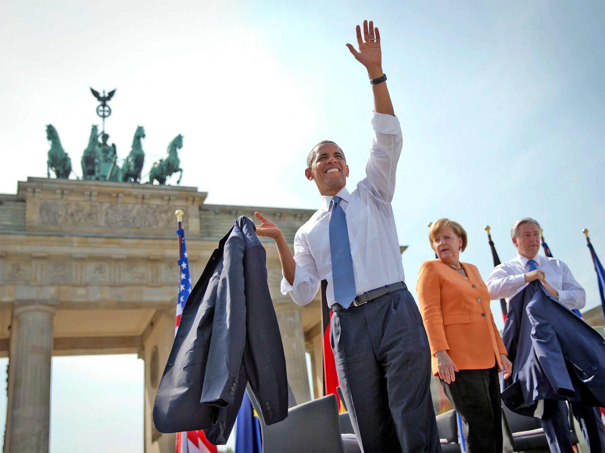Barack Obama waves to crowds at the Brandenburg Gate yesterday, watched by Chancellor Angela Merkel and the Mayor of Berlin, Klaus Wowereit