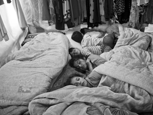 Syrian children sleeping inside their family's tent in the Bekaa Valley, Lebanon