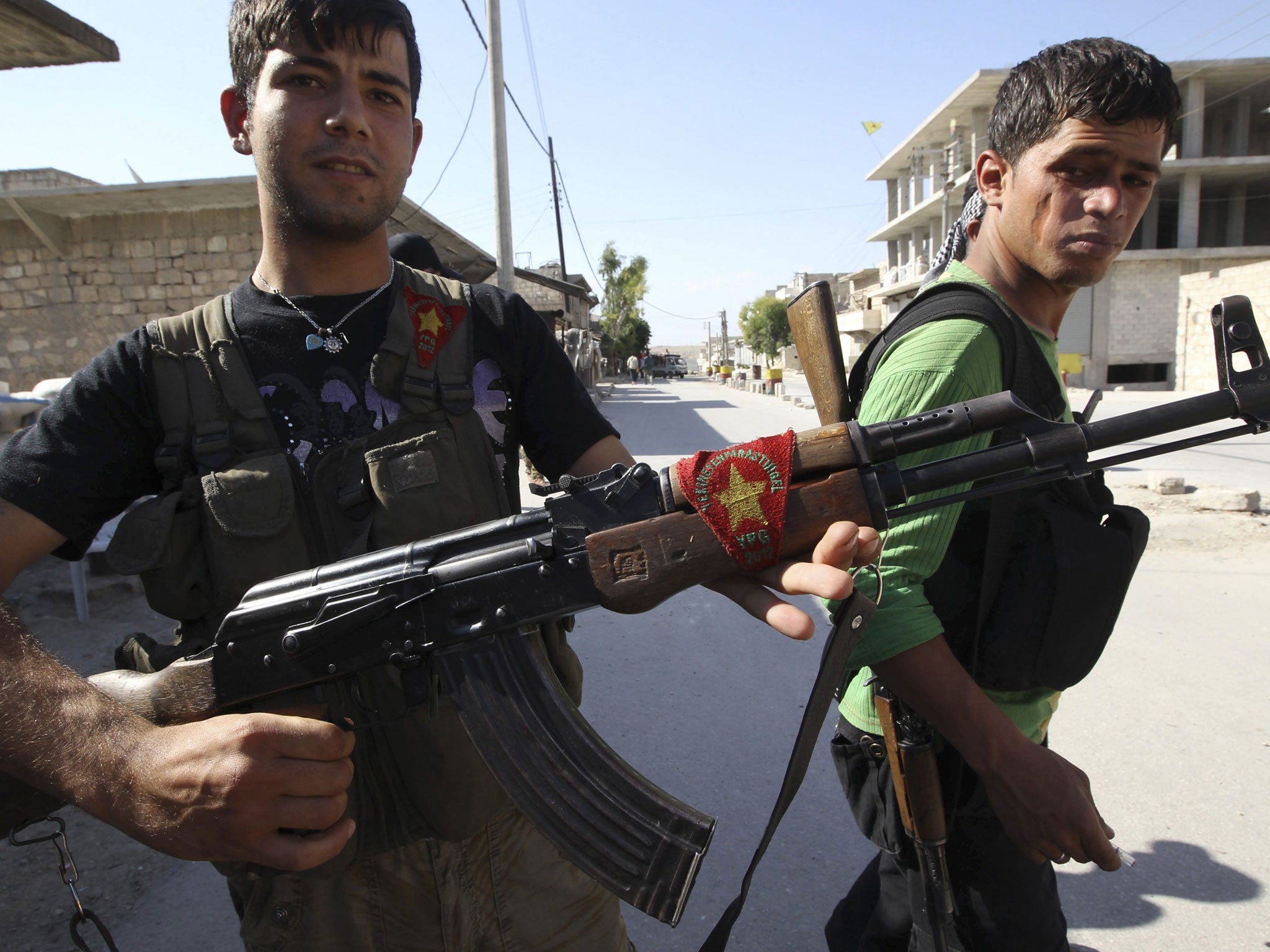 A Kurdish fighter from the Popular Protection Units (YPG) shows his weapon decorated