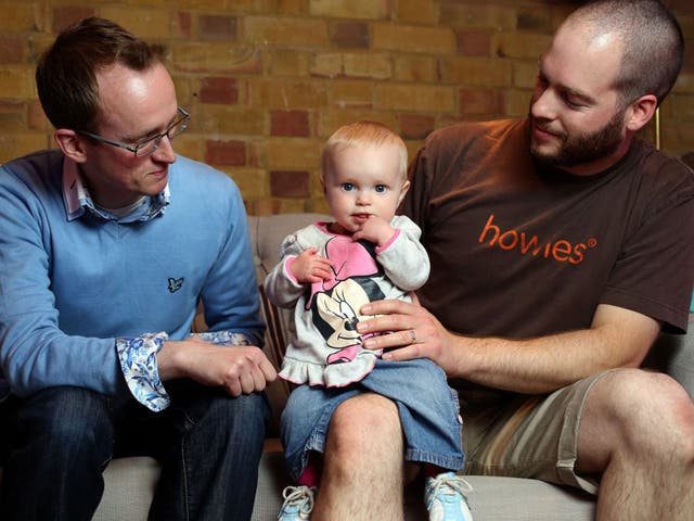 Childcare bloggers Darren Coleshill, left,  and Lewis Lippiatt look after a friend’s daughter, nine-month-old Lexi-Arizona Knowles-Smith, at the Brit Mums Live blogging conference in London