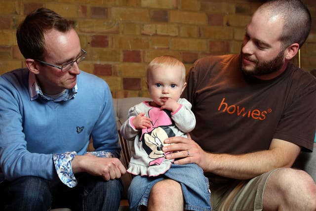 Childcare bloggers Darren Coleshill, left,  and Lewis Lippiatt look after a friend’s daughter, nine-month-old Lexi-Arizona Knowles-Smith, at the Brit Mums Live blogging conference in London