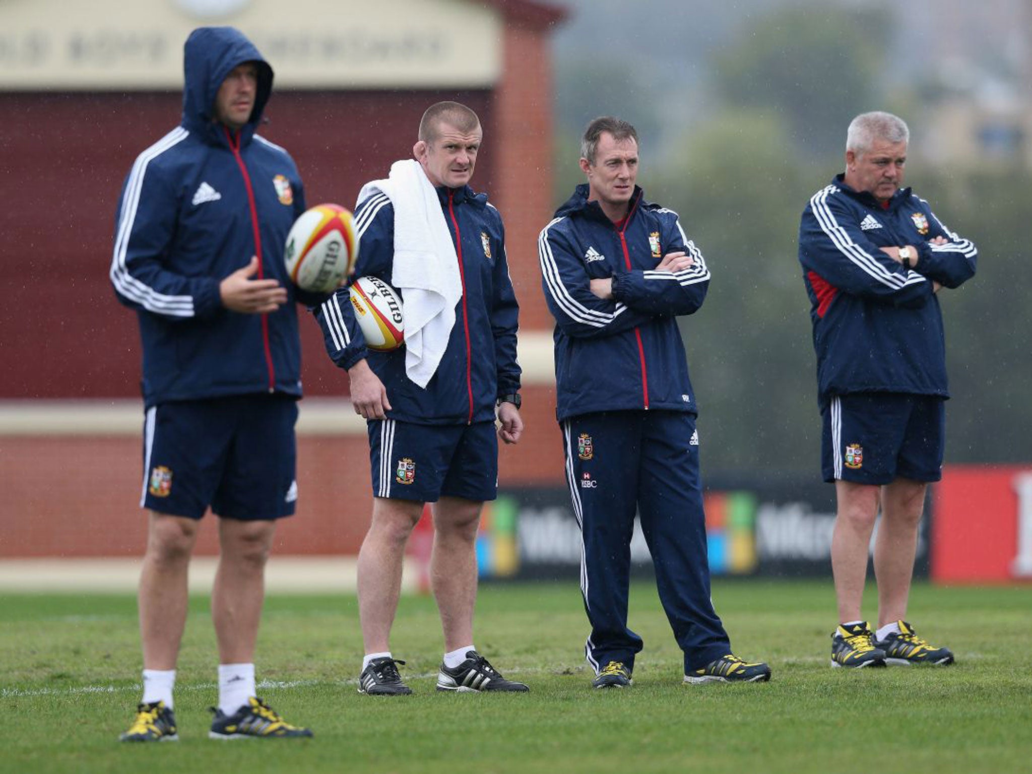 The Lions coaches watch training in the rain yesterday