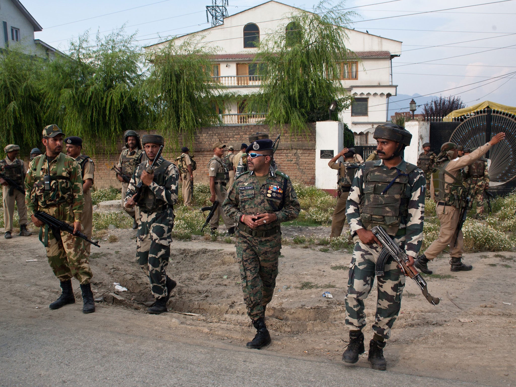 Indian policemen and paramilitary forces search for militants in residential houses after a militant attack on Indian army