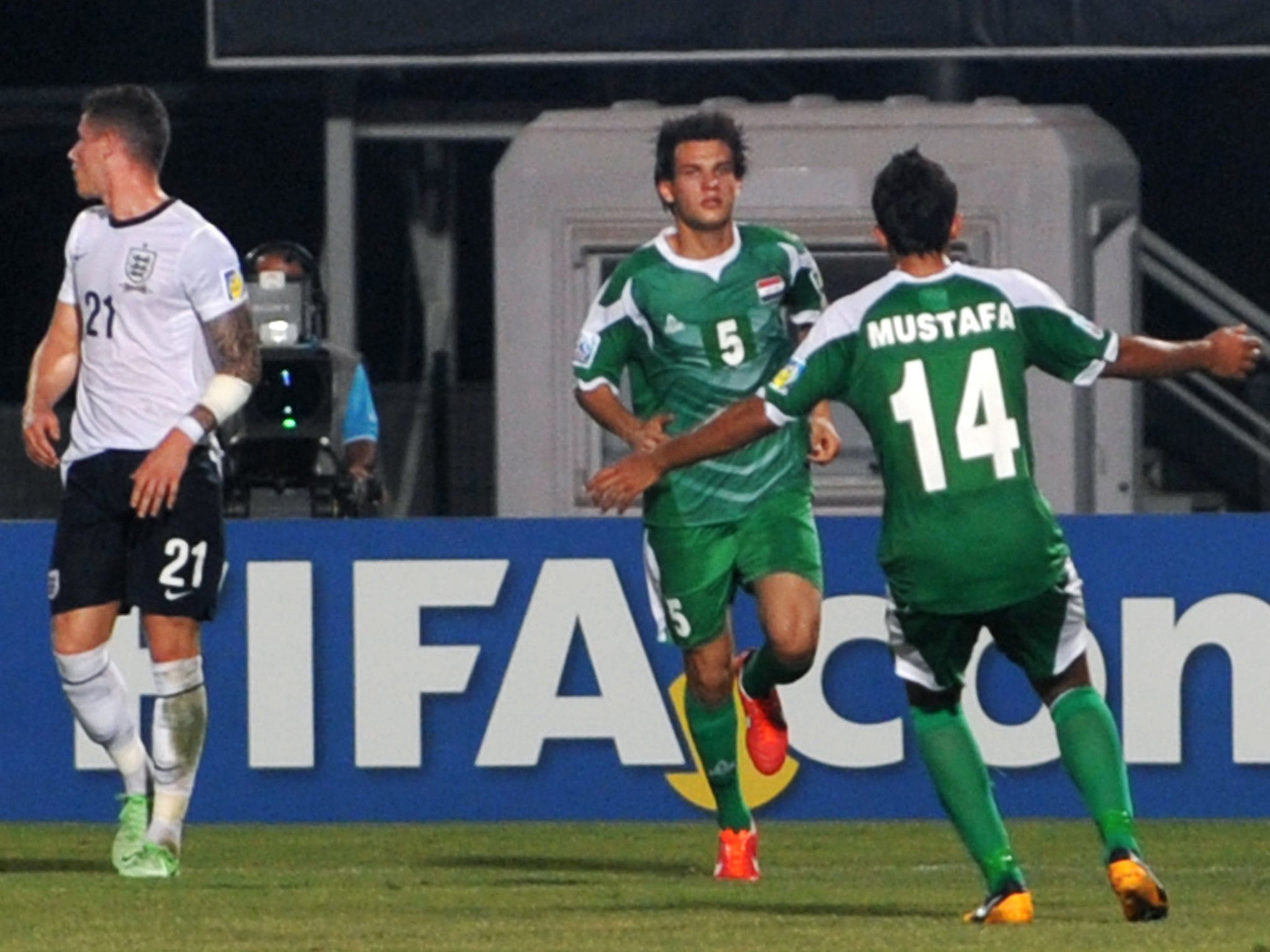 Iraq's Ali Faez (C) celebrates with Iraq's Mustafa Naghim (R) after scoring a penalty kick