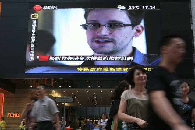 A TV screen shows a news report about Edward Snowden in Hong Kong