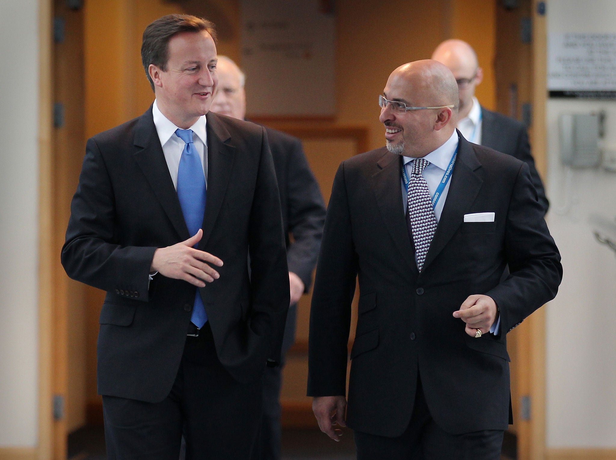 Prime Minister David Cameron (L) walks with Conservative MP Nadhim Zahawi at the Conservative Party Conference during a television interview on October 5, 2010 in Birmingham, England
