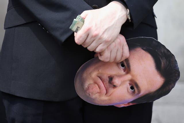 A member of the public and commercial services union holds a Chancellor of the Exchequer George Osborne face mask at a demonstration on Whitehall on June 27, 2013 in London, England. The union members were expressing their opposition to the 11.5 billion GBP cut to public spending outlined by the Chancellor of the Exchequer George Osborne in the House of Commons yesterday.