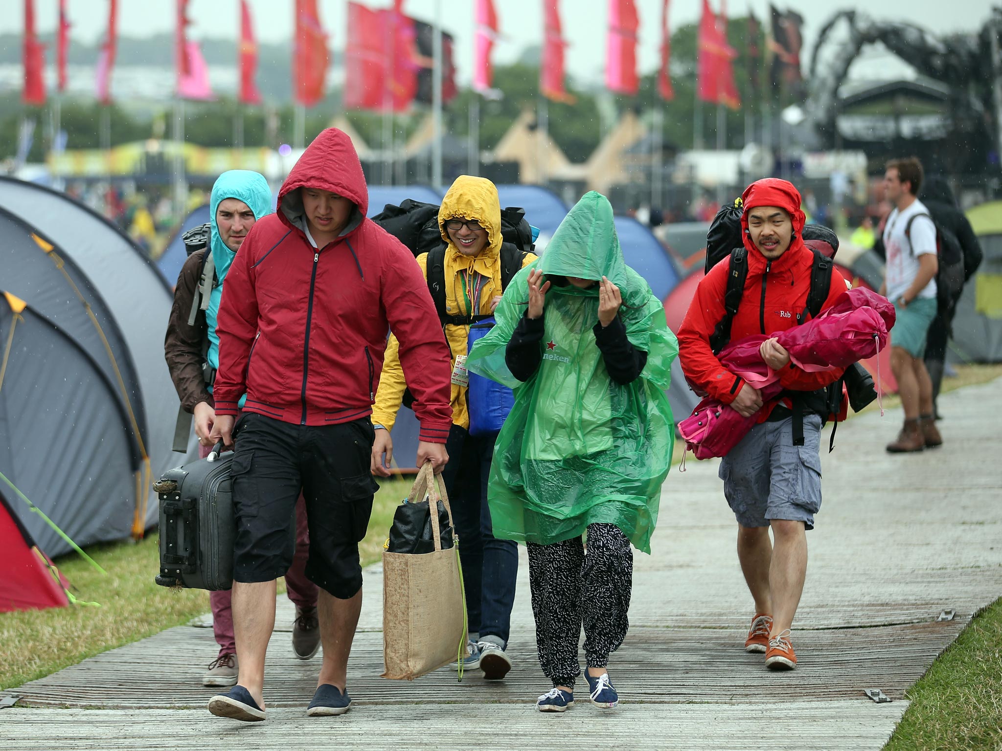 Festival goers walk in the rain at Glastonbury Festival last year with similar scenes expected this weekend