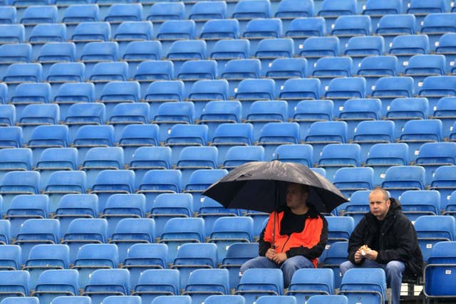 Spectators wait in the rain for the first practice runs at Silverstone