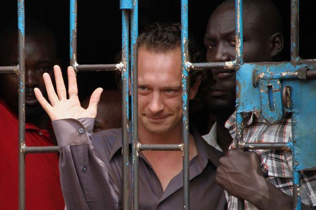 British theatre producer David Cecil waving from a court cell at the Makindye Court on September 13, 2012 in Kampala, after being arrested for staging a play about a gay man despite a temporary ban by the country's media authorities