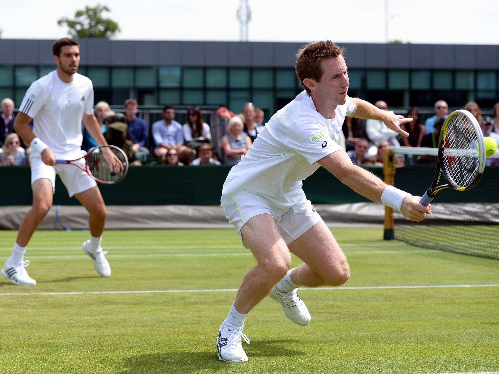 Grass master: Jonny Marray hits a volley in his doubles win