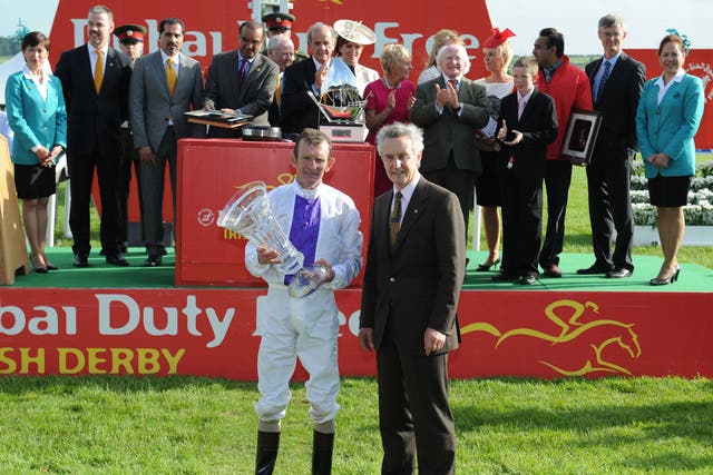 Trainer Jim Bolger, right, poses with winning jockey Kevin Manning, left, after Trading Leather won the Irish Derby at the Curragh