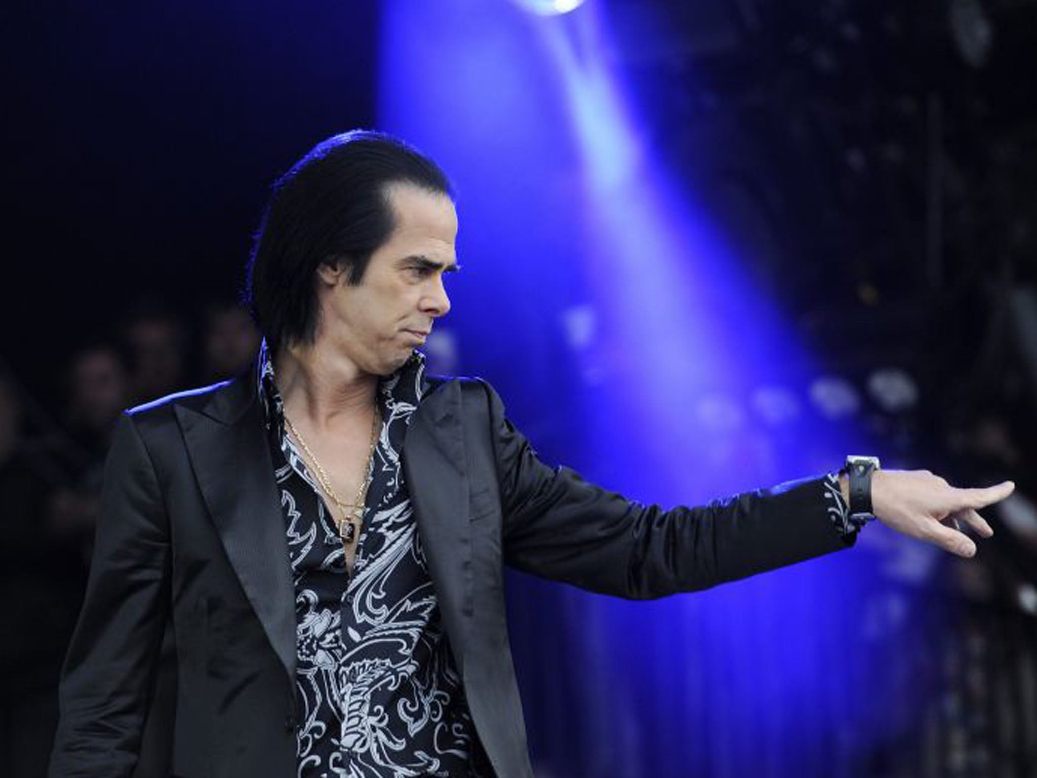 Nick Cave stares into the crowd as he performs with his bad the Bad Seeds