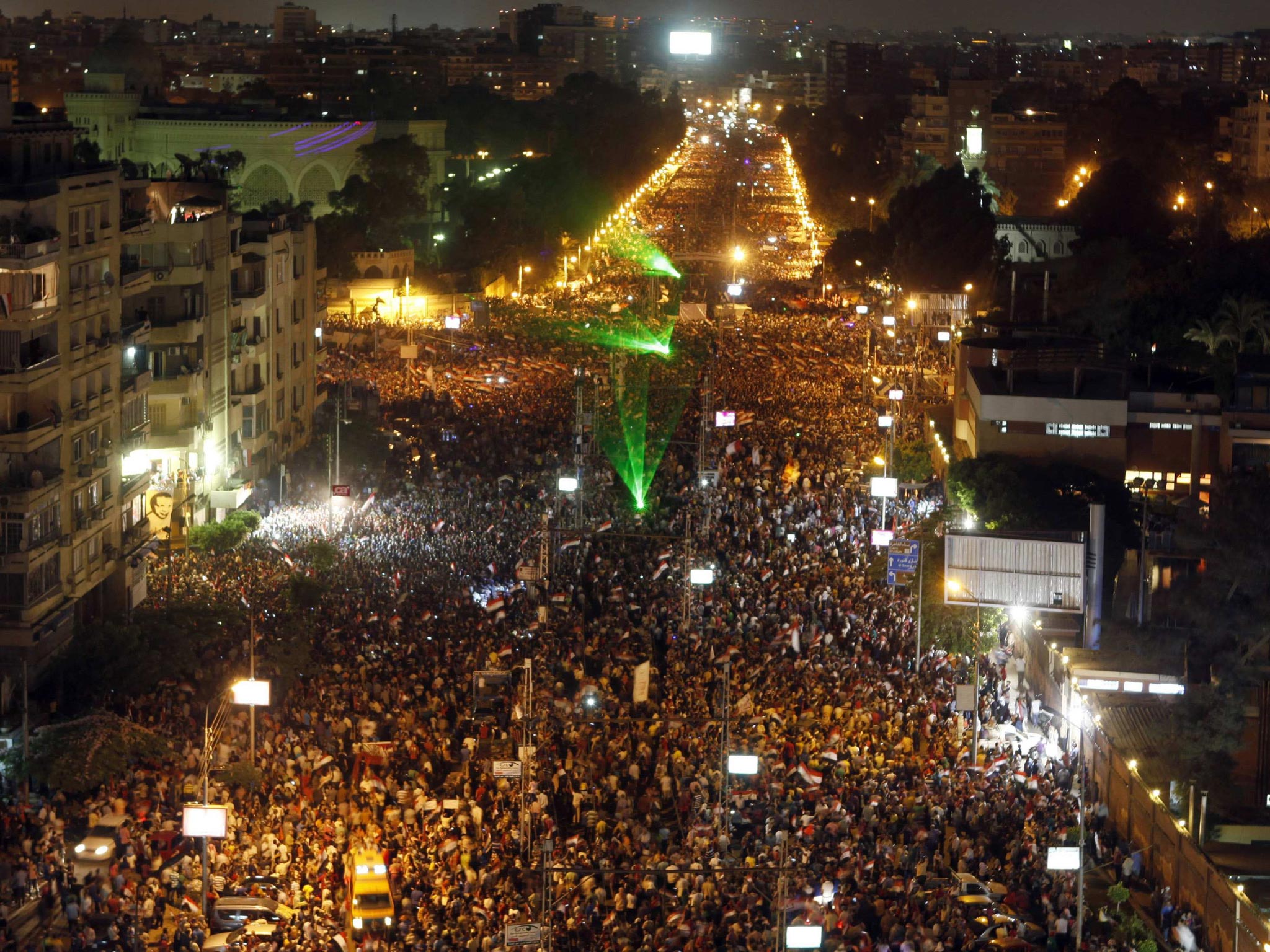 Protesters opposing Egyptian President Mohamed Morsi wave Egyptian flags and shout slogans against Morsi and members of the Muslim Brotherhood during a protest in front of El-Thadiya presidential palace in Cairo