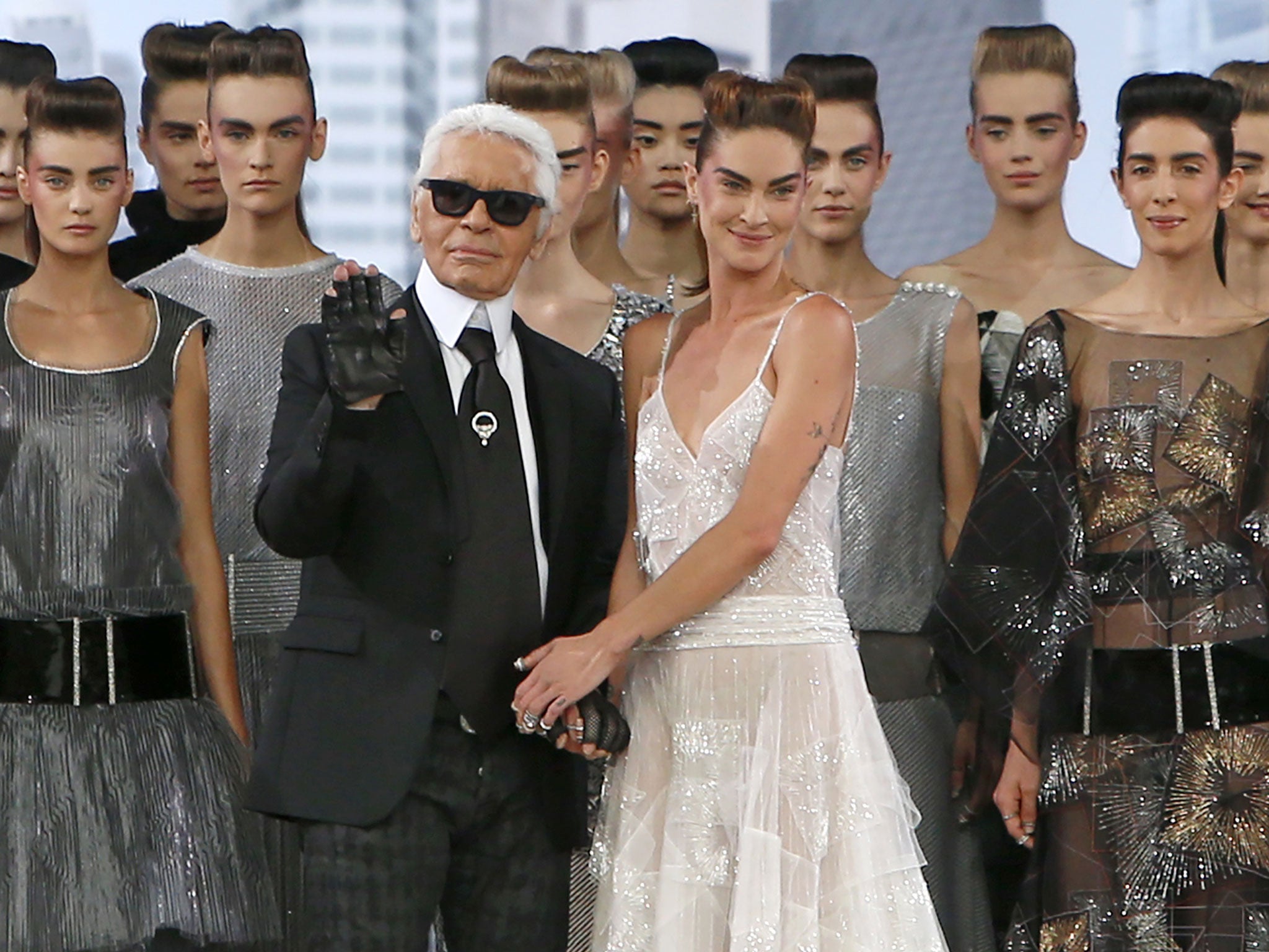 Karl Lagerfeld, surrounded by models, acknowledges applause following the presentation of his Chanel show.