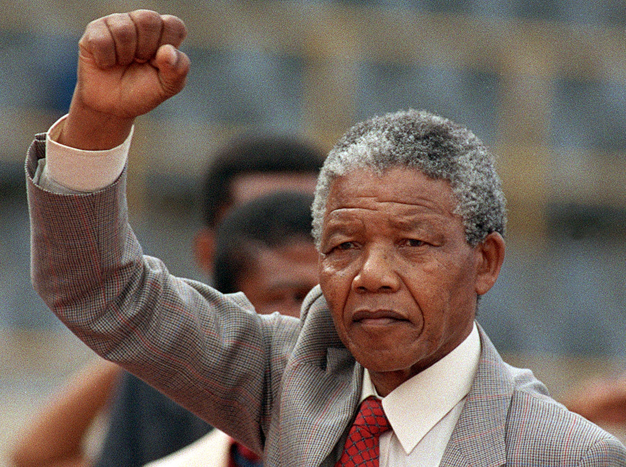 Anti-apartheid leader and African National Congress (ANC) member Nelson Mandela raises clenched fist, arriving to address mass rally, a few days after his release from jail, 25 February 1990, in the conservative Afrikaaner town of Bloemfontein, where ANC was formed 75 years ago.